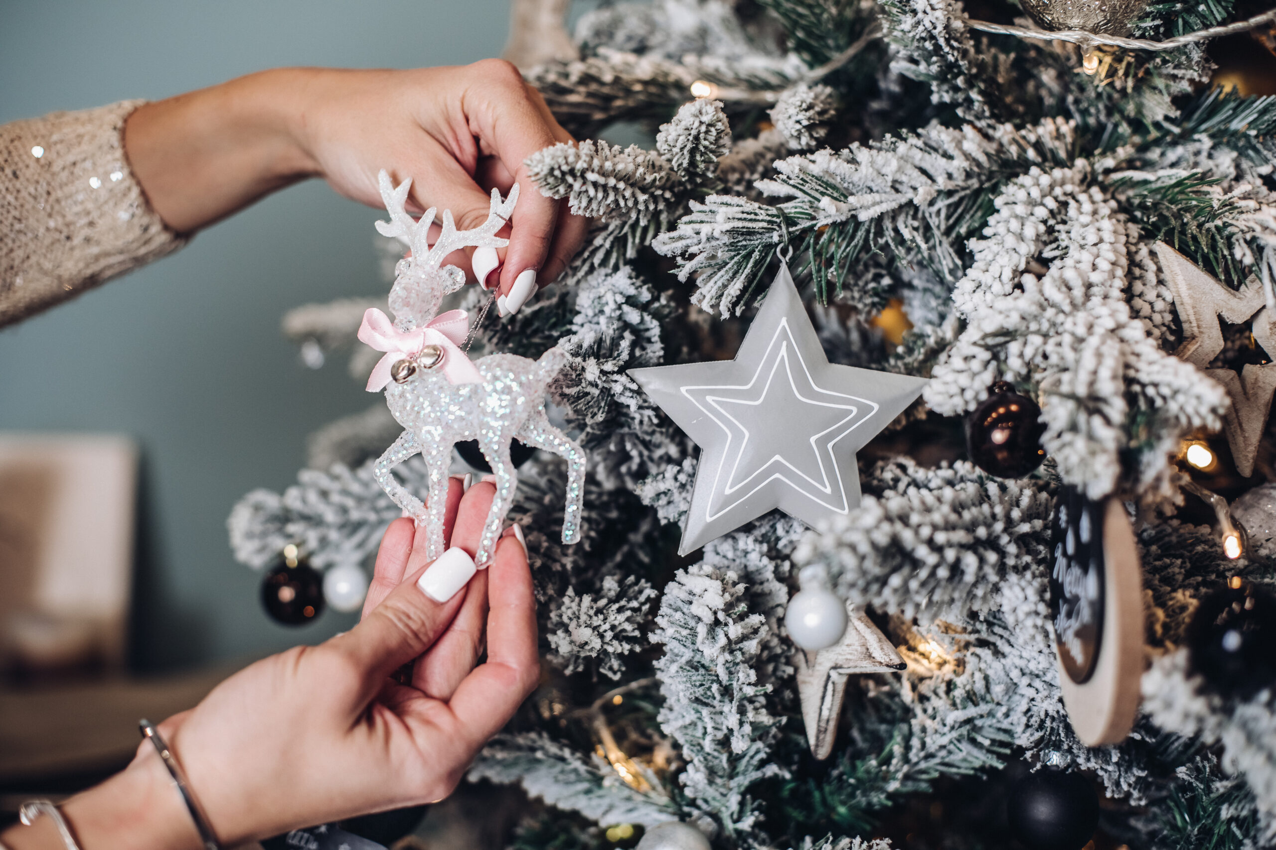 Woman placing Christmas toy on the tree